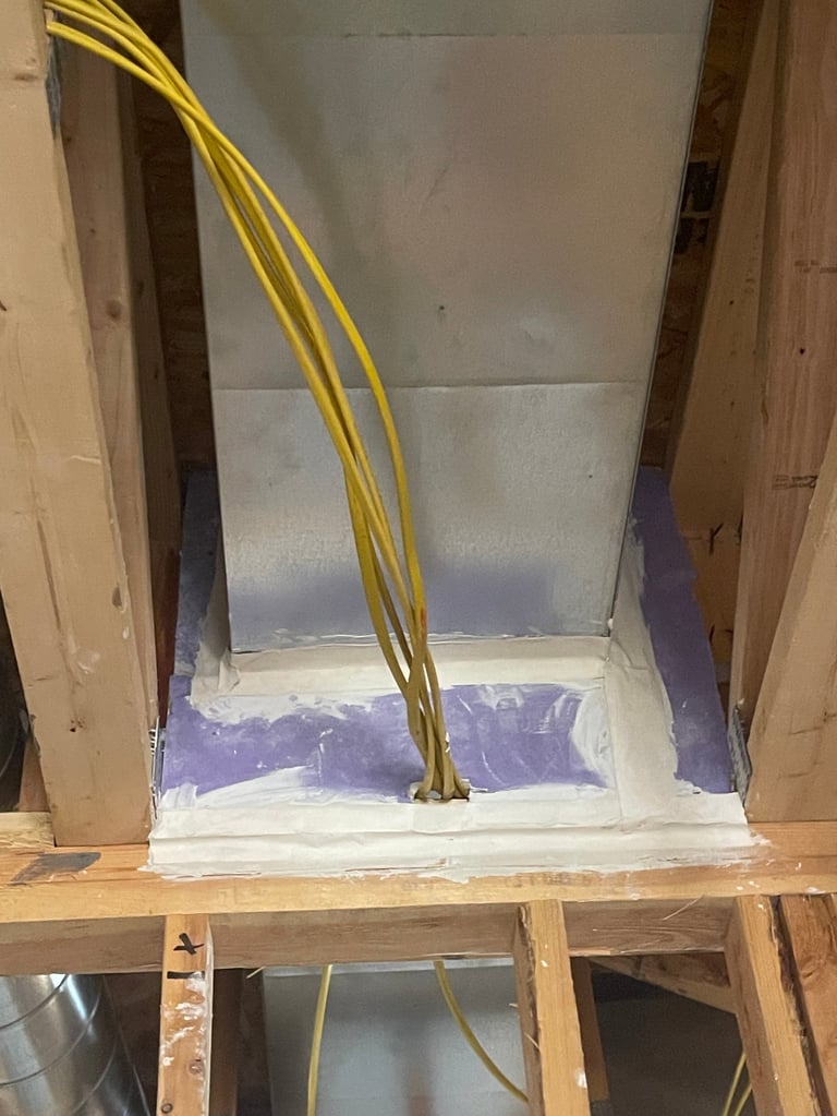 Construction site showing recessed shower installation with metal backing and yellow electrical conduit running through wooden framing studs
